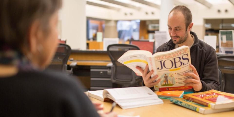 A man looks at a book titled: The Big Book of Jobs.