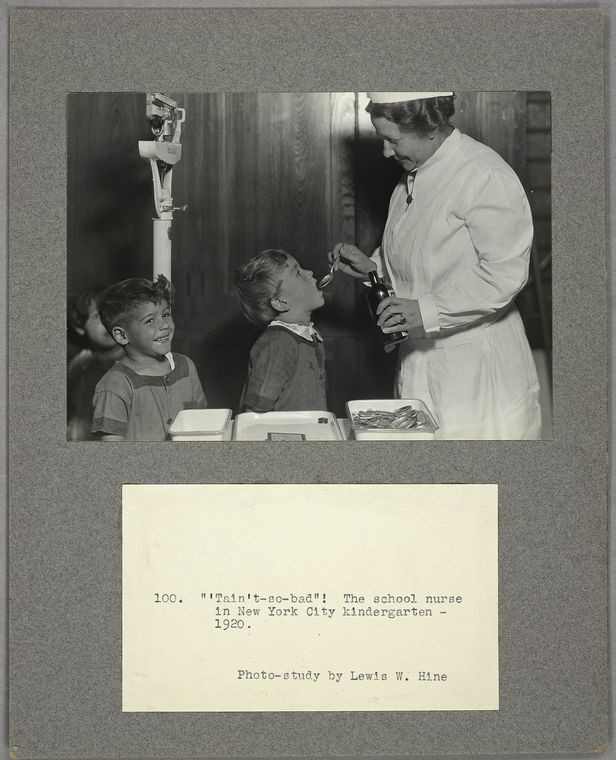 nurse giving child a spoonful of medicine