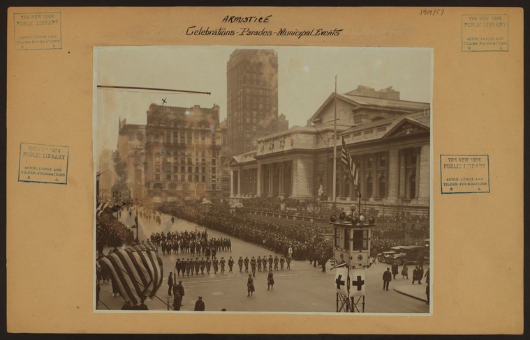 soldiers parade past NYPL Main building with crowd watching
