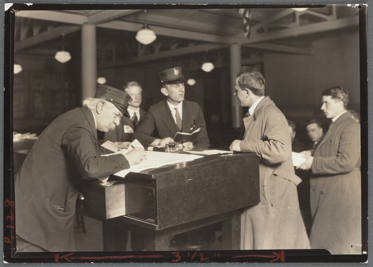 official at Ellis Island interviewing a man 