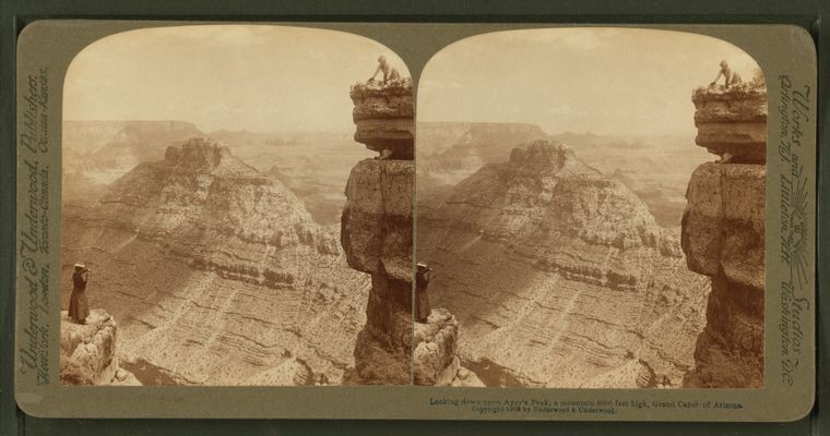 a woman looks down from a tall peak at the Grand Canyon