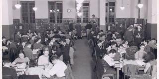 Black and white photograph of a library room packed with young adults. A caption notes: Student attendance is over 50,000 annually.