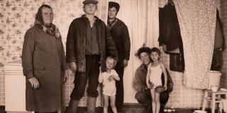 Black and white photo of four adults and two children. 