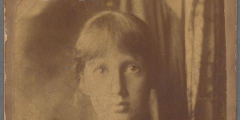 A sepia portrait of a teenage girl with bangs and hair pulled back, wearing a high-collared top and posing in front of a curtain.