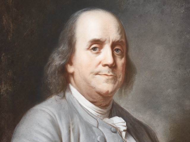 Portrait of Benjamin Franklin wearing a grey suit and vest, he has a thin tired smile