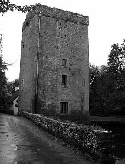black and white photography of a castle and road with stone wall leading to castle
