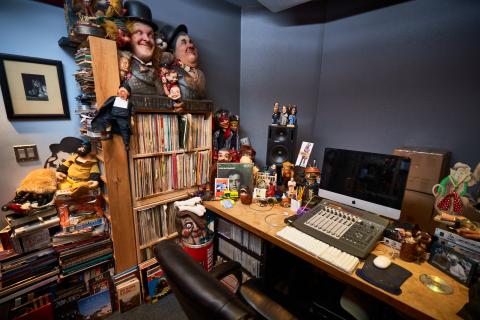 Photo of Hal Willner's studio with a computer desk and shelves filled with collectibles.